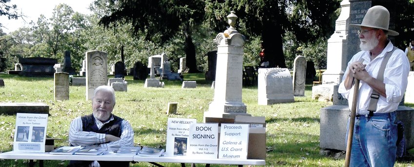 Ronn Toebaas (left) sold copies of his book &ldquo;Voices from the Grave Vol. Three&rdquo; at the 2022 cemetery walk. Gary Jobgen (right) played an undertaker in the cemetery walk.