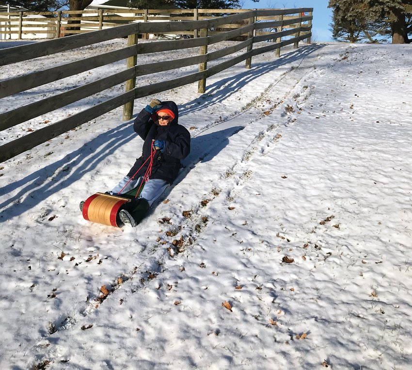 At age 99 Doris Trader enjoys a ride down the hill on a toboggan. This was an annual ritual.