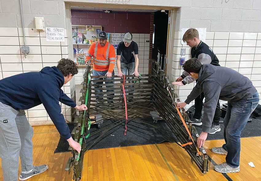 Damon Dittmar, Duane Brotherton, Jack Ketelsen, Sam Rife and Landis Longmore move a part of the deconstructed bleachers out of the gym.
