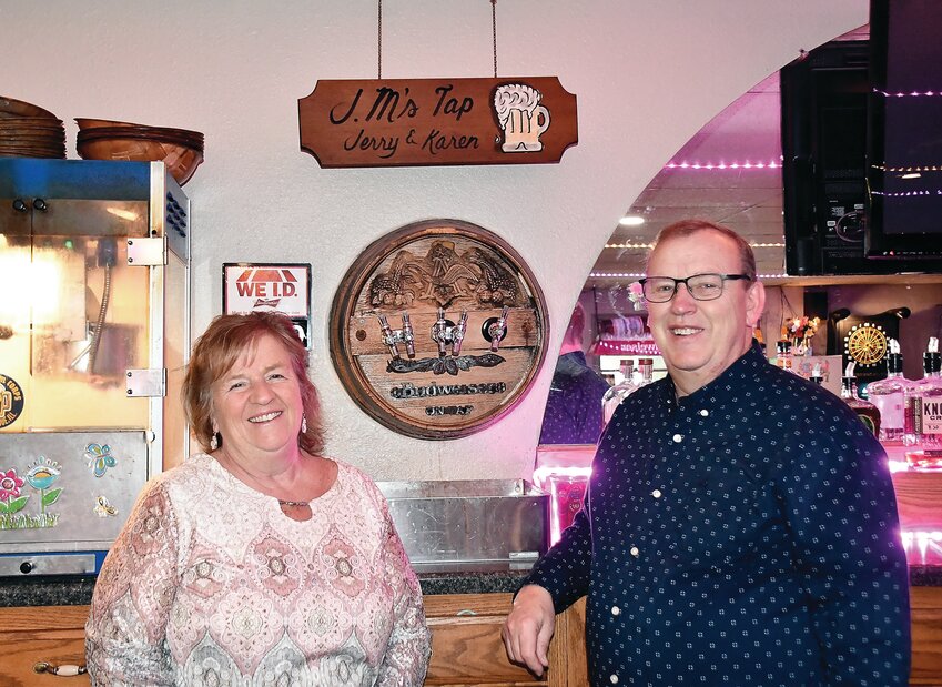 Karen and Jerry Meyer stand next to their sign which resides behind the bar.
