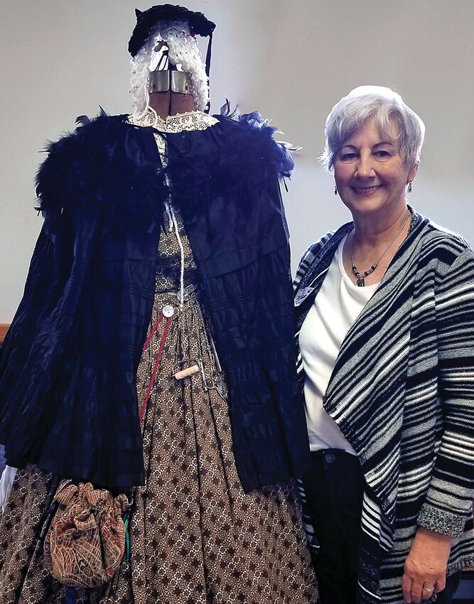 Karen Brose poses with a dress women would wear during the Civil War, ahead of her presentation at the Stockton Heritage Museum.