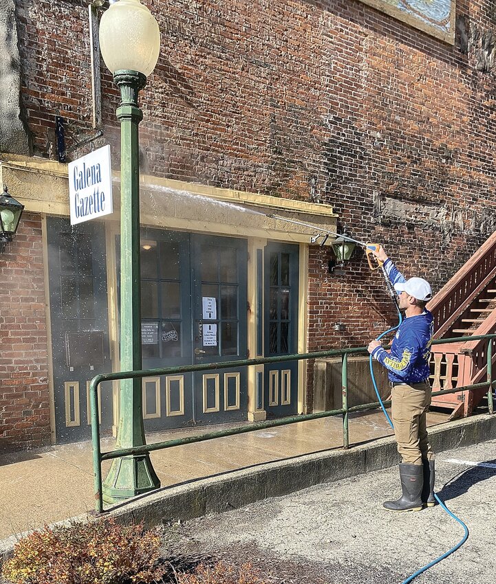 As part of Galena&rsquo;s Clean Up the City activities, Perfectly Klean Exteriors power washes the entrance to the office of The Galena Gazette and Galena Area Chamber of Commerce.