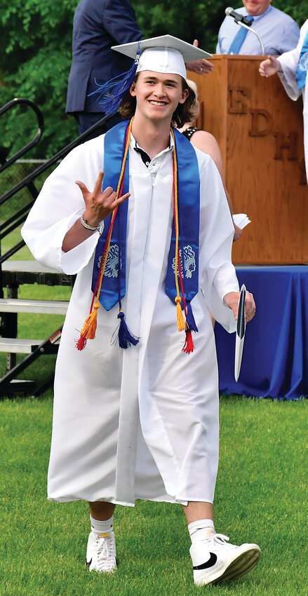 Liam Thumser flashes a rock &lsquo;n roll sign after receiving his diploma.