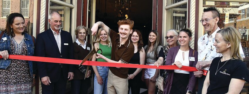 Participating at a ribbon cutting at The Hideaway, 120 N. Main St. on Thursday, May 25 are from left, Brianne Van Hemert, Colin Sanderson, Denise Spielman, Alexis Engle, Austin Scott (owner), Candy Bauer, Laney Thunder, Lisa Radke, Madeline Hawkins, Rick Fronek and Michelle Bass. Not pictured: Danielle Cline.