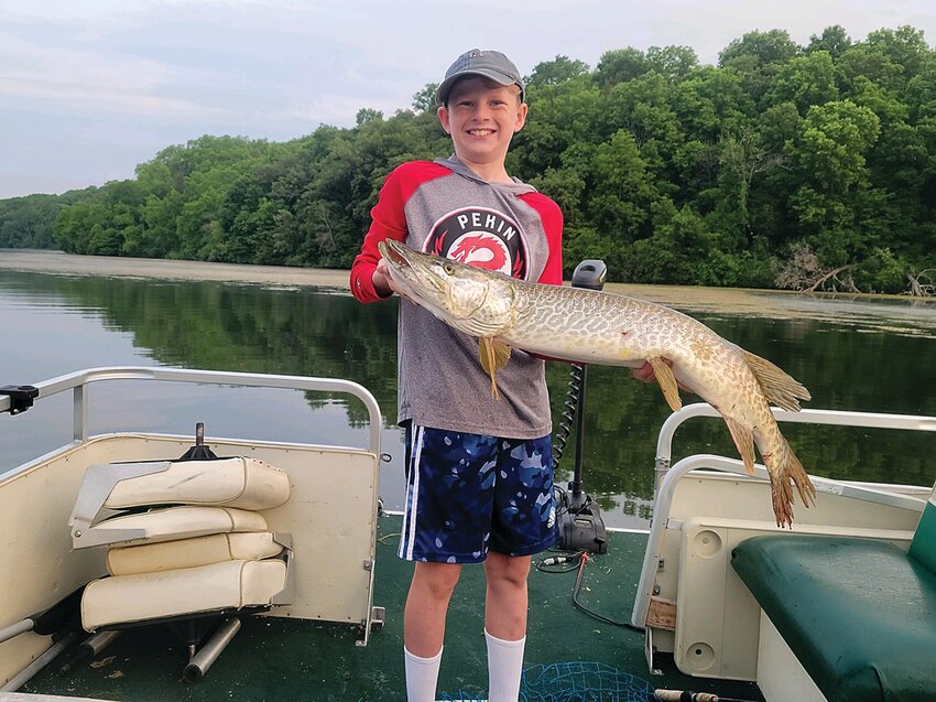 Parker proudly holds the 42-inch musky he caught.