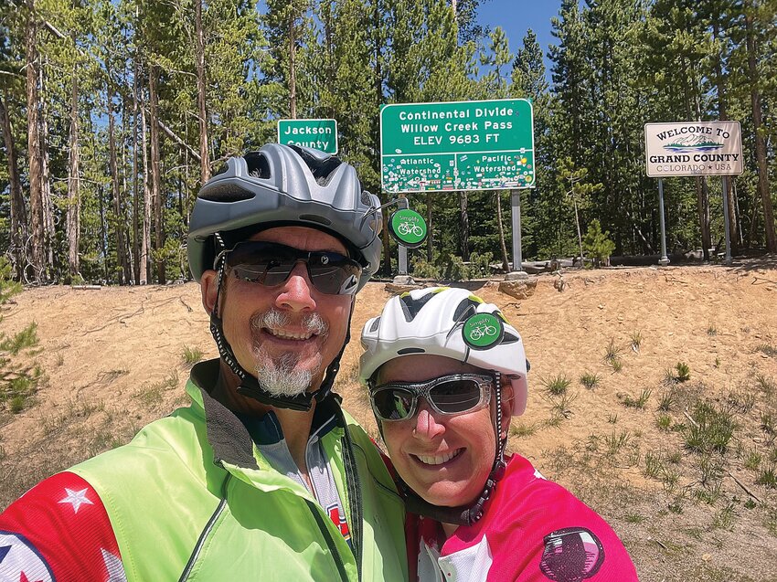 Matt Nelson and Leisa Graves pose next to a sign noting where the Continental Divide is. They cycled on a route that took them across the divide several times.