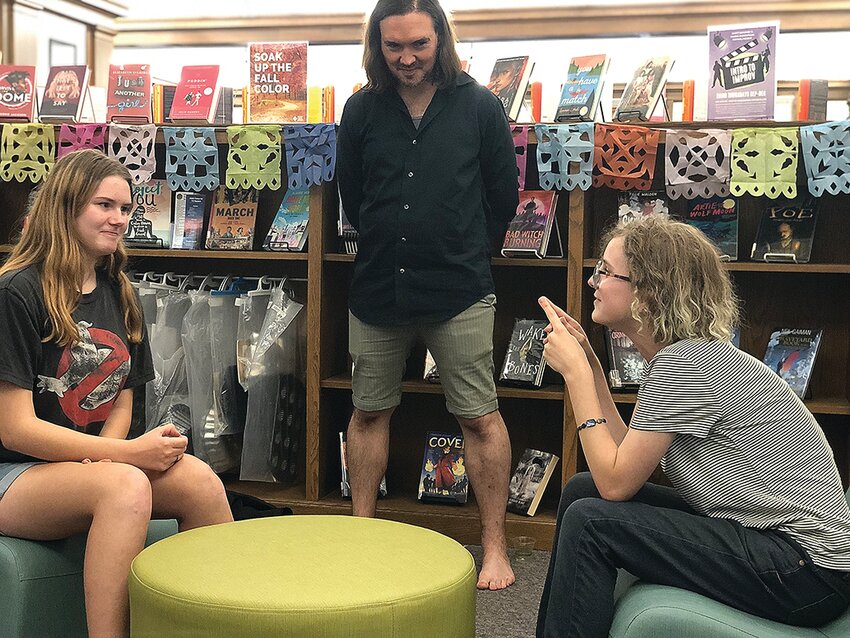 Abigail Issleb (left) and Ellimena Henderson (right) improvise a scene at Galena Public Library&rsquo;s Intro to Improv class in September while Scott McKinsey coaches them. The next Intro to Improv class is on October 19 at 5:00 p.m.