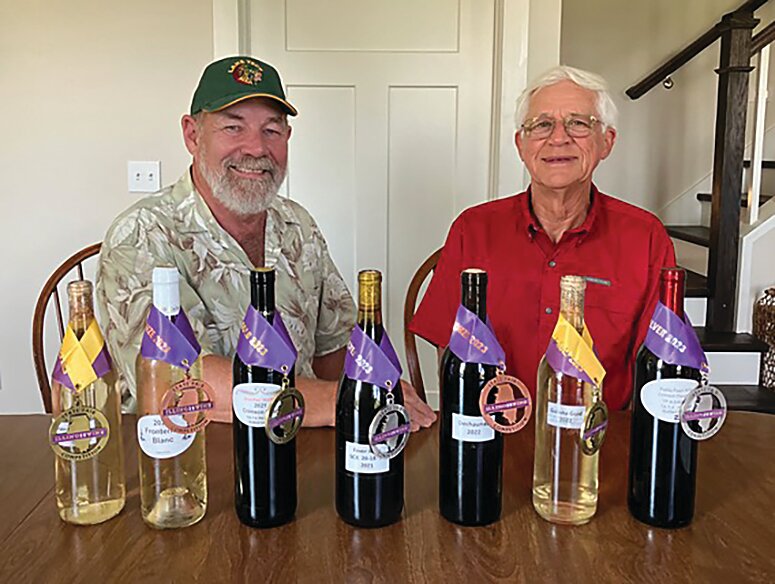 Ed Strenski, left, and Dennis Kueter, right, pose with their wines which won awards at the Illinois State Fair this year. Strenski won double gold (every judge rated the wine gold) in the amateur competition for his St. Pepin 1 and Galena Gold wines. His Fever River and Dechaunac also won awards. Kueter won gold for his Crimson Pearl wine. He also won awards for Red Blend and Frontenac Blanc. Another member of the NIWG, Lynn Kaufman, was recognized for her Concord wine.