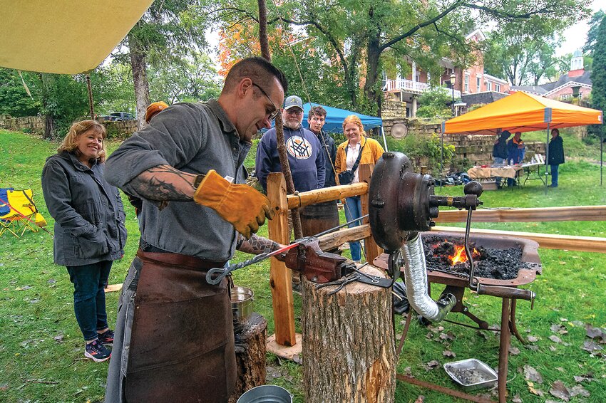 There are lots of events over the weekends in Galena, especially in the fall. This past weekend there were two big events, the Other Side of the Anvil and 20 Dirty Hands. Dan Simon, Galena, a 12-year volunteer at Galena&rsquo;s Blacksmith historical site, twists the red hot steel into a decorative fireplace poker as visitors attending the Other Side of the Anvil watch.