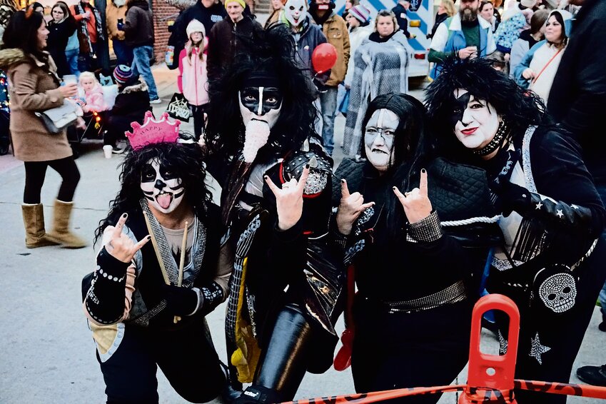 A group of Kiss impersonators give the rock &lsquo;n&rsquo; roll sign.