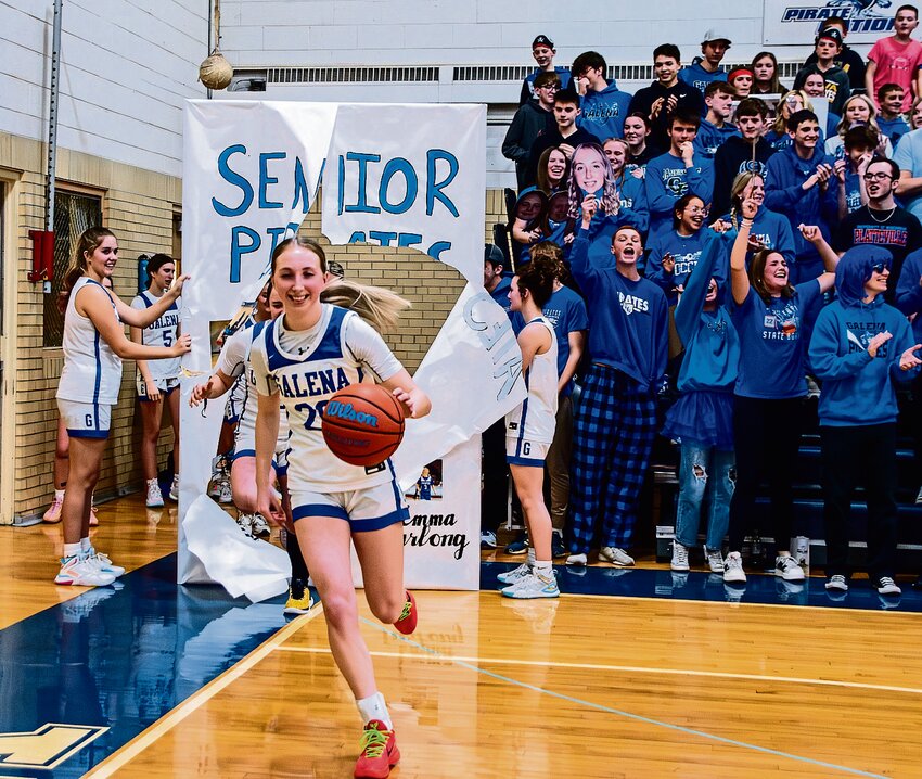 Addie Hefel runs through the senior banner while the student section cheers for the team.