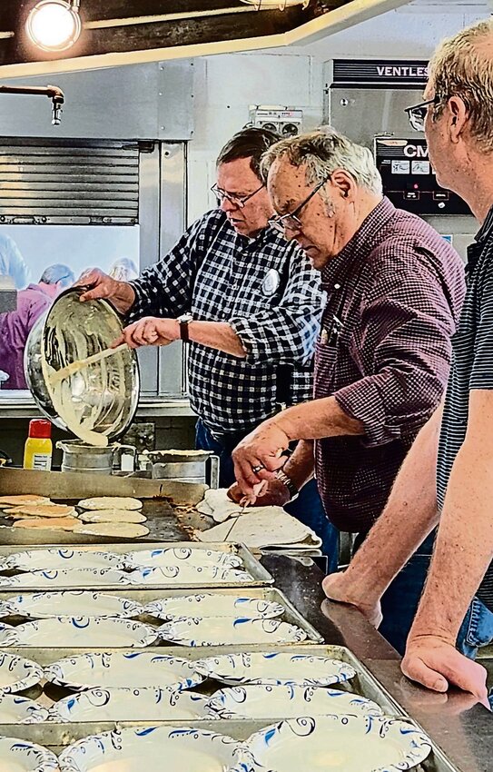 Chet Schuler (left), Larry Cording (center) and Bob Singleton (right), help make and plate the pancakes.
