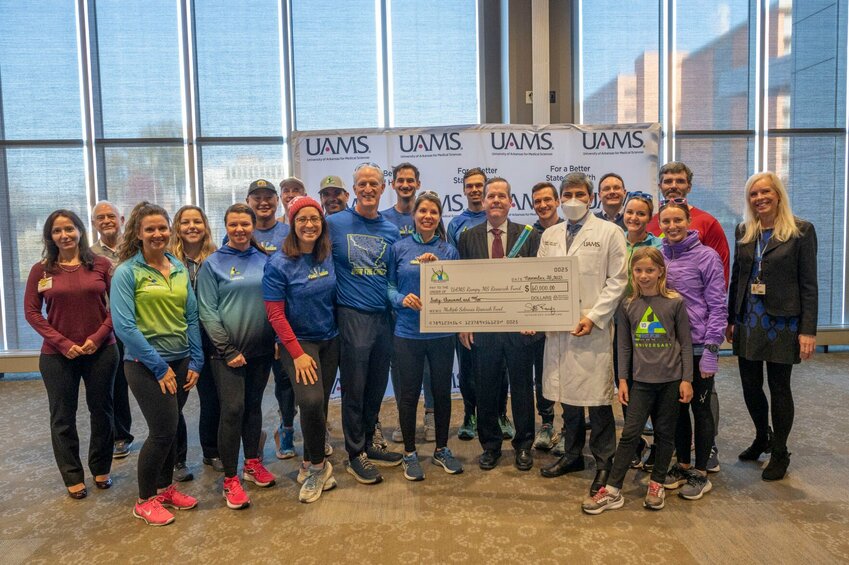 Walkers and runners deliver a check to the UAMS Neurological department after their relay race. The run was organized as part of the Rampy foundation’s Giving Tuesday efforts. 