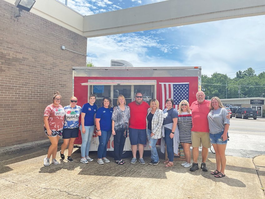 8.9 Arvest H&amp;H  Donna Braymer/Staff  Several Arvest Bank employees and local Realtors paused for a photo before they purchased snow cones from Seasonal Bliss. The fundraiser raised $1,898 for Hearts &amp; Homes.