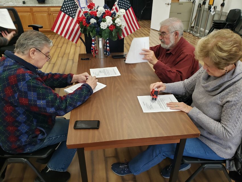 Boone County Election Commission members (from left) John Cantwell, chairman, John Holmes and Lavonne McCullough affix their signature to election results after certification Friday afternoon. JAMES L. WHITE/STAFF