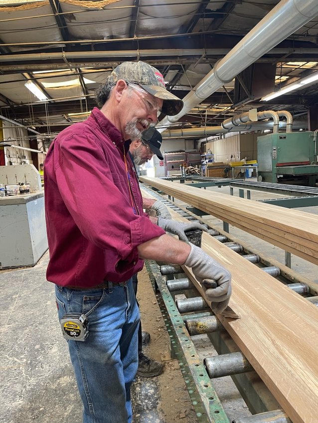 Gary Matlock has worked at Wabash for 17 years and is applying putty to the glued seams of the boards that will become new bleachers at the former junior high school gym as part of the Creekside project.