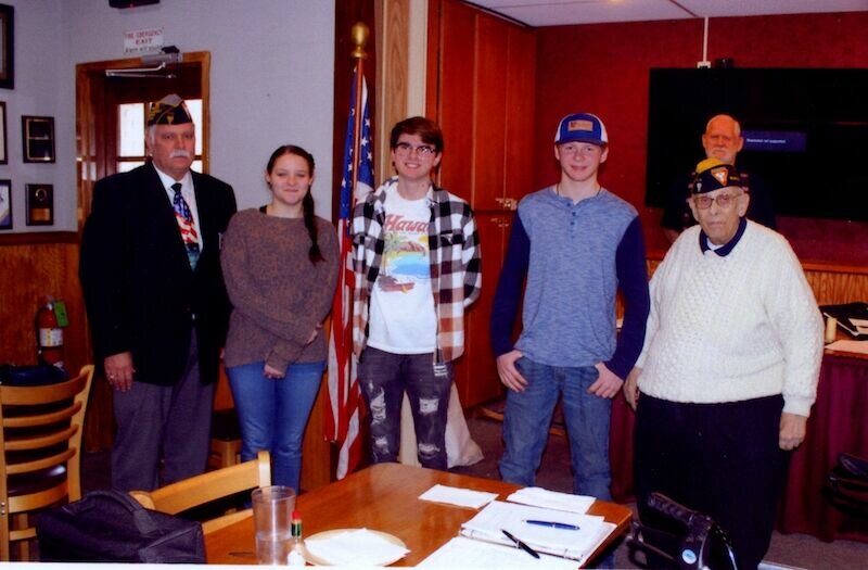 Emmet Smith (far left) presented (from left) Emma Wilson, Noah Sutton and Peyton Noell with the help of fellow members (right) Richard Baehr and (back) Gene Woody.