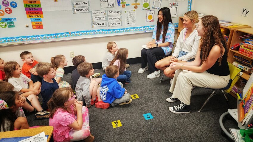 Harrison High School students (from left) Napat Mekkringkrai, Elyssa O'Neal and Jade Metivier encourage young kindergartners to read. CONTRIBUTED PHOTO