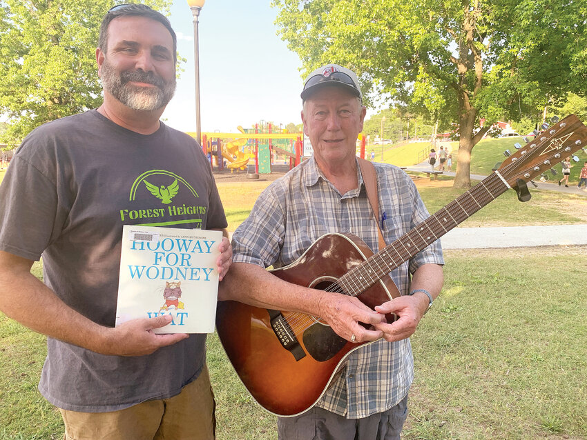 Mark Ditmanson read the book &ldquo;Hooray For Wodney Wat&rdquo; to the children at the Lake Harrison Park Thursday evening for the first reading of the summer for the Boone County Imagination Library&rsquo;s &quot;Reading at the Park&quot; event. Ditmanson is the principal at Forest Height Elementary School. At right is Ken Savells who played songs with his guitar to the large crowd prior to the book reading. Reading at the park is at 6:30 pm on Thursday nights near the pavilion by the playground equipment on Lake Harrison and is sponsored by the Boone County Imagination Library