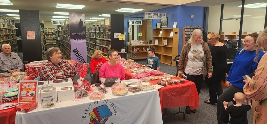 Volunteers greet customers as they shop for sweets at the Bone County Friends of the Library bake sale on Valentine's Day. Customers had a large variety of cakes, cookies, and other treats to choose from. JEFF BRASEL / STAFF
