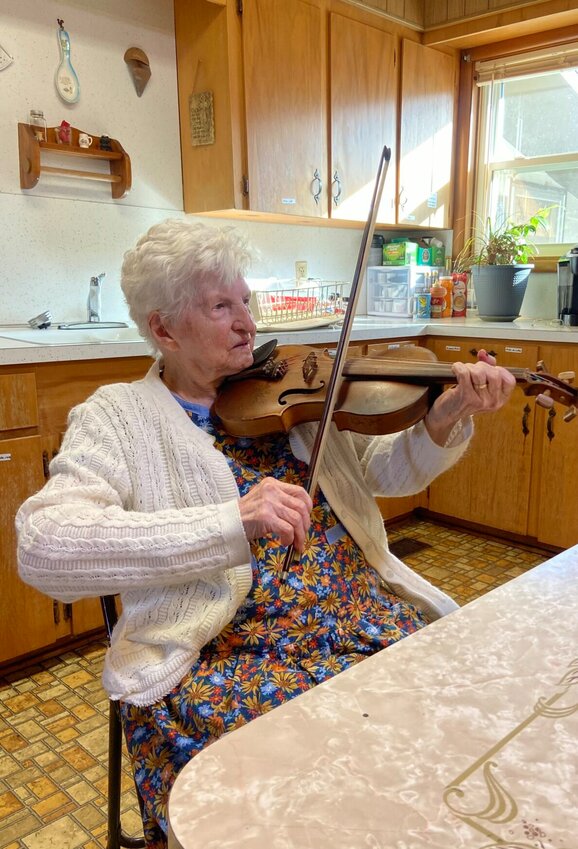 107 year-old Violet Hensley plays one of her handmade fiddles in the kitchen of her Yellville home. LORETTA KNIEFF / STAFF