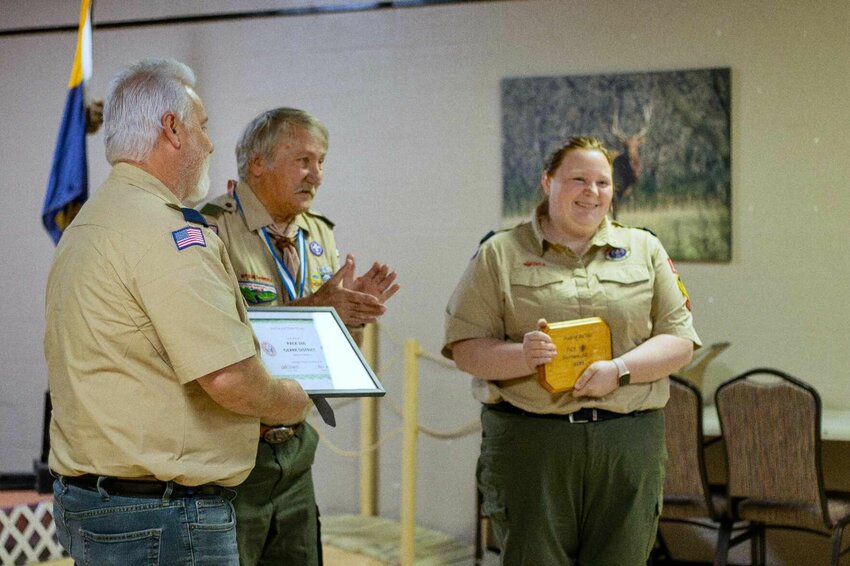 Jeff King (left), Cubmaster Pack 160, Harrison, and Sage Kinney, Den Leader Pack 160, Harrison, receive the Pack of the Year Award from District Volunteer Bruce Bieschke (center).