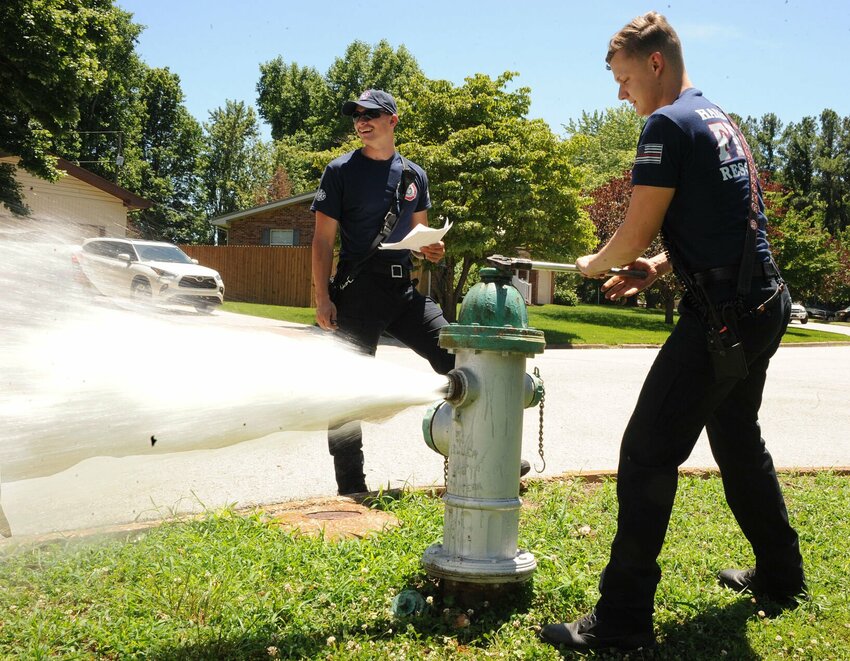 Harrison Firefighters Caden Robertson (left) and Donovan Armstrong test the water pressure and flow. &nbsp;This fire hydrant is located on Mimosa Street in the Skyline area. CONTRIBUTED PHOTO / LEE H. DUNLAP