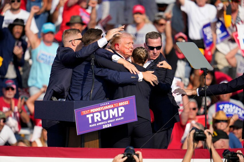 Republican presidential candidate former President Donald Trump is helped off of the stage by secret service agents after a shooter fired at him during a campaign event in Butler, Pa., Saturday, July 13. AP PHOTO