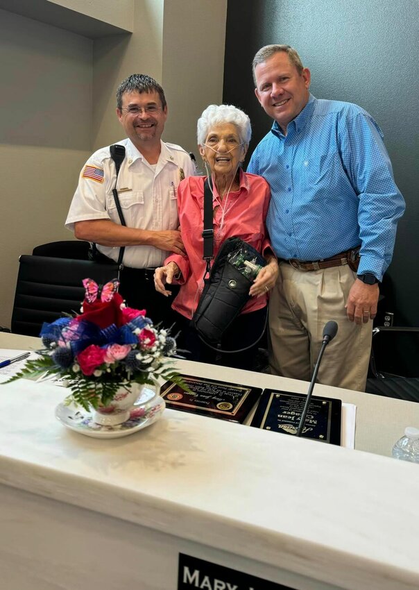 Harrison Fire Chief Marc Lowery and Chief of Police Chris Graddy present Mary Jean Creager with a plaque at the Thursday, Aug. 8 meeting of the city council. Creager was honored for her service to the community as a council member and beyond. CONTRIBUTED PHOTO