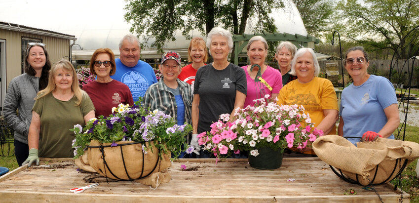 Boone County Master Gardeners prepare floral hanging baskets that will be displayed on the downtown square in Harrison. Pictured include (left to right) Mallory Jeffers, Teri Gregory, Judy Willey, Alan Gregory, Polly Leimberg,  Susan Timbrook, Linda Mann, Roxana Creamer, Sue Carper, Joyce Sattler, and Flavie Lear. CONTRIBUTED PHOTO / LEE H. DUNLAP
