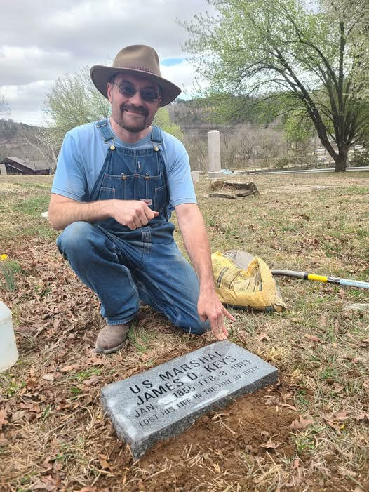 Travis Holt with the stone of Marshall James Keys, who was killed in a shootout in Jasper at the turn of the century. Holt says that marking unmarked graves is his life's work.