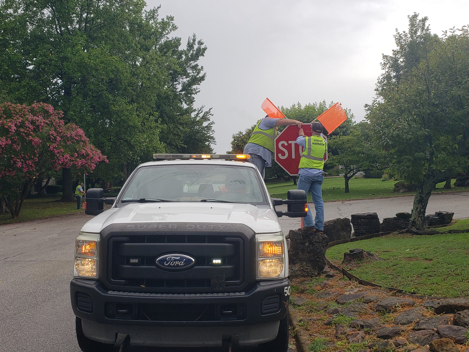 City workers install a new stop sign at Speer Drive and Eugene Street, one of three intersections that are now all-way stops.