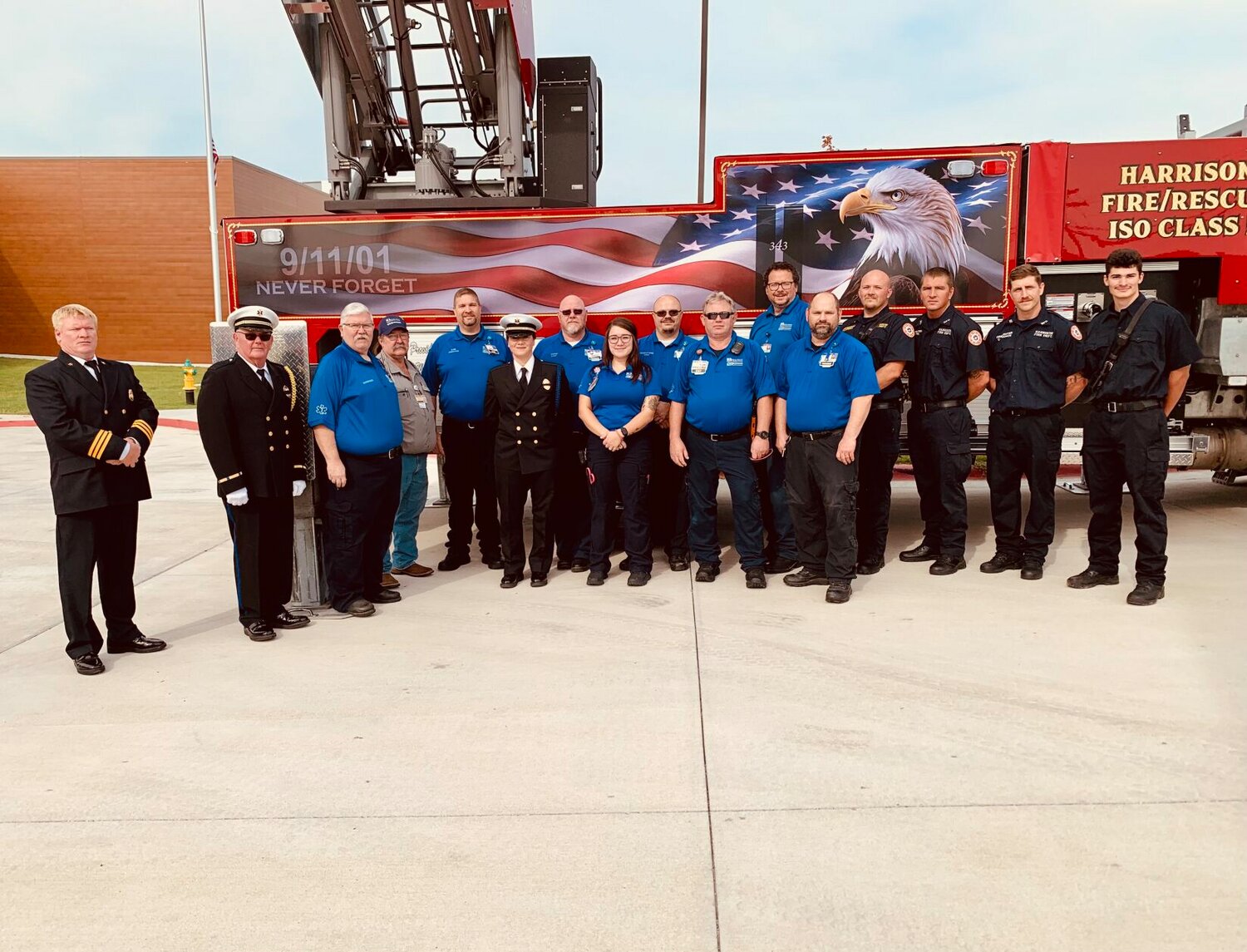 Harrison firefighters and EMS members stand in front of the 9/11 graphic located on the side of the new ladder truck at the Harrison Fire Station. CONTRIBUTED PHOTO/LEE H. DUNLAP