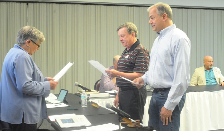 Corporate board chairman Joanie Corry swears in new directors, from left, Edsel Archie Frye Jr. and Doyle Baker. Sitting behind them is Mark Quinton, who will serve a new one-year term. (Lewis Delavan photo)