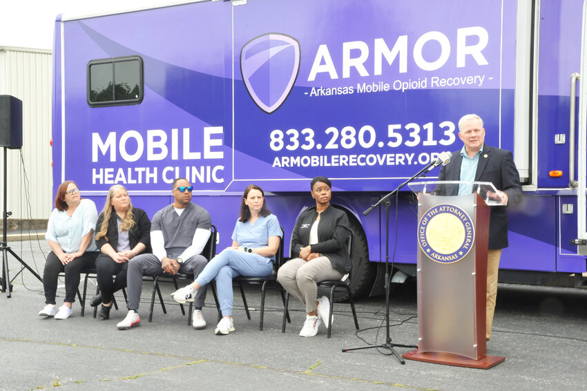 Staff of Arkansas Mobile Opioid Recovery listen as Attorney General Tim Griffin addresses the crowd at the introduction of ARMOR's new mobile health clinic van. The mobile clinic will regularly visit Second Baptist Church's feeding program at Tractor Supply in Malvern. (Lewis Delavan photo)