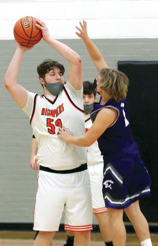 With a seven inch height advantage, Hillsboro's 6'3&quot; Ian Malloy keeps the ball out of the reach of 5'8&quot; Emiliano McGill of Litchfield during the waning moments of the Toppers' 67-36 victory over the Purple Panthers on Friday, Feb. 26.