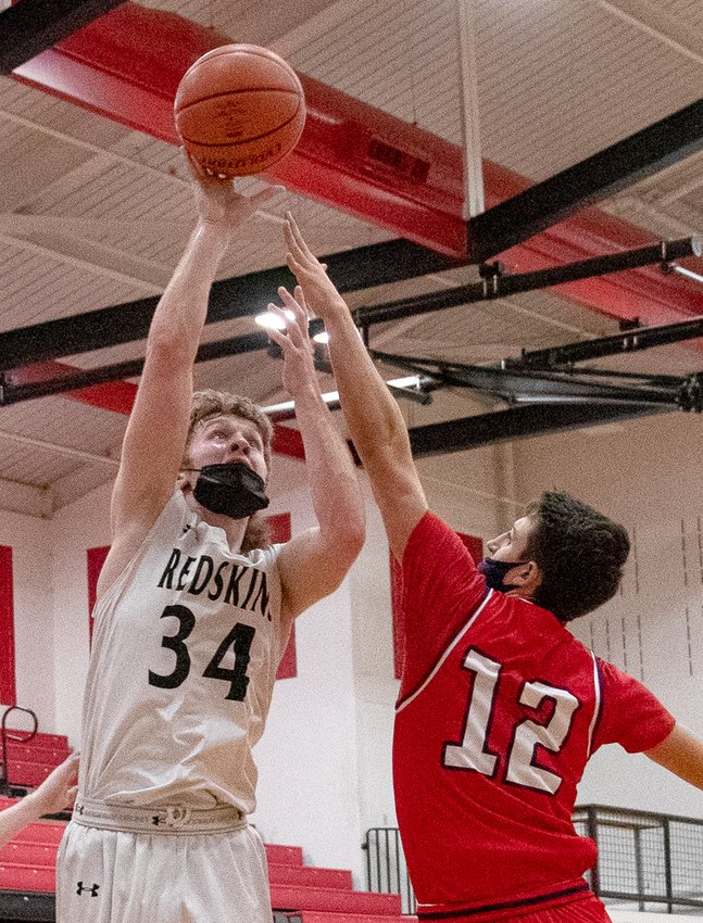 Nokomis&rsquo; Jake Johnson shoots over the top of Calvary&rsquo;s Brennan Crowder during the Redskins&rsquo; home game against the Saints on Tuesday, March 9. Johnson had 15 points in the Redskins&rsquo; 66-37 win over the Saints, one point shy of the team lead, held by Seth Johnson with 16.