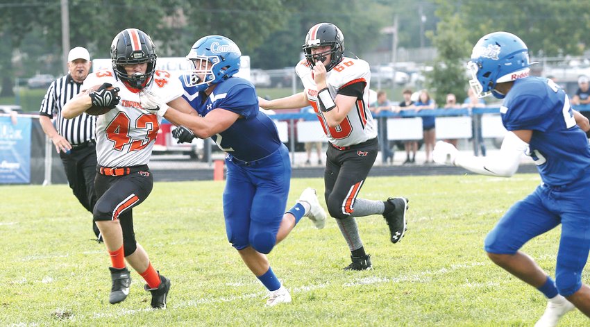 Hillsboro running back Joe Keiser tries to shrug off a Comet defender during the first quarter of the Toppers&rsquo; opening night game in Bond County.