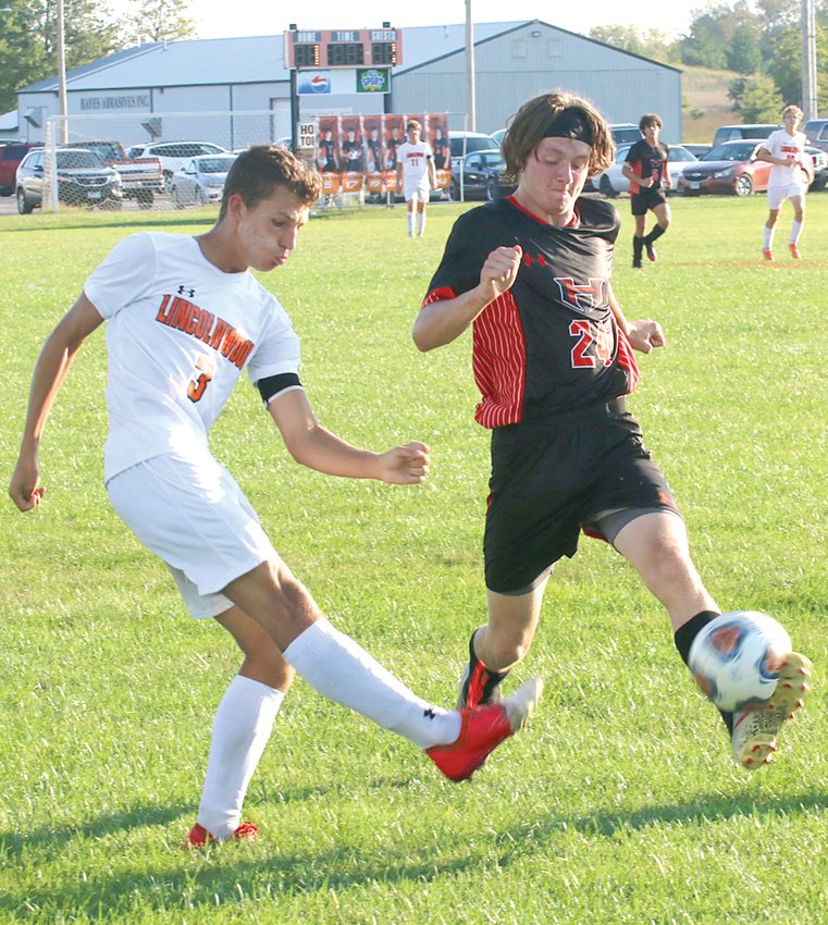 Hillsboro&rsquo;s Matt Page (in black) gets a foot on Levi Weir&rsquo;s shot during the second half of the Toppers&rsquo; home game against Lincolnwood on Monday, Sept. 20. The two seniors resulted in the only two goals of the 1-1 tie between the two rivals.