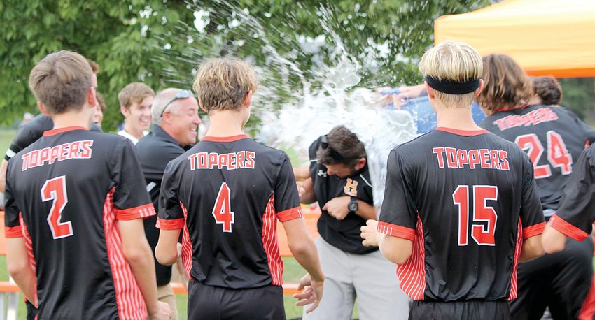 Hillsboro High School boys soccer coach Jason Burke gets an impromptu shower in celebration of the Toppers' 5-0 win over Litchfield on Thursday, Sept. 30, which clinched the Toppers' third consecutive South Central Conference championship with a 6-0 record.