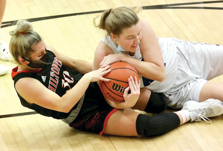 Hillsboro's Ally Schnarre (#30) wrestles for a loose ball during the Toppers' road game with Greenville on Thursday, Dec. 2. Hillsboro put together an all-around effort to score their first South Central Conference win of the season with a 60-20 victory over the Comets.