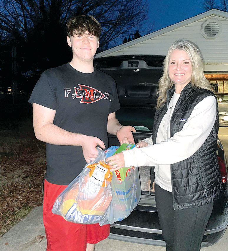 Nokomis High School junior Mason Morris, at left, started a grocery pick-up service this fall. He is pictured above delivering groceries to Jodi Reynolds.