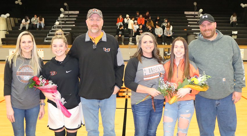 The two senior members of the Hillsboro High School girls basketball team were honored prior to the Lady Toppers&rsquo; home game against Southwestern on Wednesday, Jan. 9. Above, from the left, are Ally Schnarre, with parents Faye and Terry Traylor; and Abbigail Schreiber, with parents Georgia and Chris Adams.