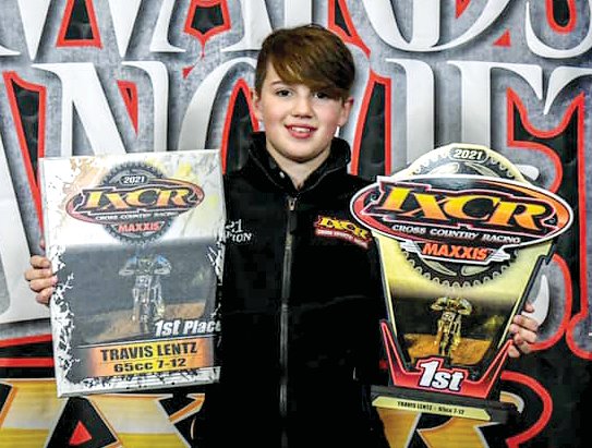 Walshville racer Travis Letnz holds up two of the trophies he won last year at the end of the year banquet for the IXCR Cross Country Series. Lentz also took first in the WFO Promotions series and was third in the GNCC national series in 2021.