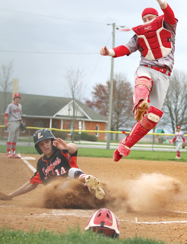 In a cloud of dust, Lincolnwood&rsquo;s Braden Whalen slides safely underneath Vandalia catcher Aiden Polite for one of his two runs scored against the Vandals. The run would be one of 12 scored for the Lancers on April 11, but a nine run sixth inning by the visitors resulted in a 14-12 win for the Vandals.