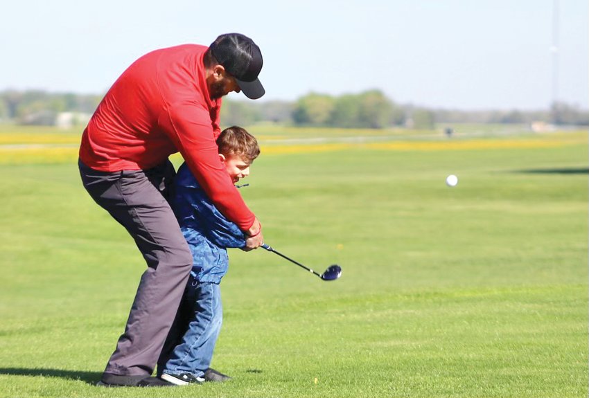 With some help from his dad Jason, Camden Burke tees off to start the fourth annual Crush for Camden&rsquo;s Crew Golf Outing on Saturday, May 7, at Indian Springs Golf Course in Fillmore. The event raises funds for specialized movement therapy for Burke, who was born with Cri du Chat Syndrome, and for scholarships for other families with special needs children.