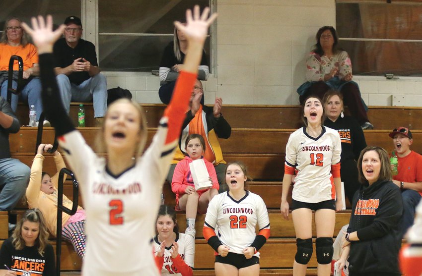 While senior Avery Pope (#2) celebrates on the court, Kierstyn Denney, Taryn Millburg (#22), Jazmin Seaton-Hobson (#12) and Coach Kimberly Denney celebrate from the bench after Lincolnwood scored the final point in their two-set win over Greenfield-Northwestern at the Lincolnwood Regional championship game on Oct. 27. The title was the Lancers' third straight regional crown and moved them on to the sectional semifinal against Mendon Unity on Monday, Oct. 31, in White Hall at 7 p.m.