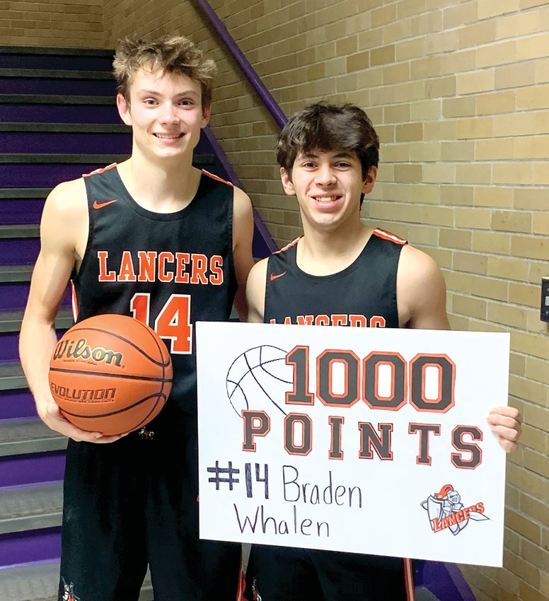Braden Whalen (left) and Zake Guzman (right) of the Lincolnwood-Morrisonville co-op boys basketball team commemorate Whalen&rsquo;s 1,000th career point after the Lancers&rsquo; 62-58 win over Taylorville on Monday, Feb. 6. The duo are the team&rsquo;s only two seniors this year and will be honored Friday, Feb. 10, before their home game against Calvary.