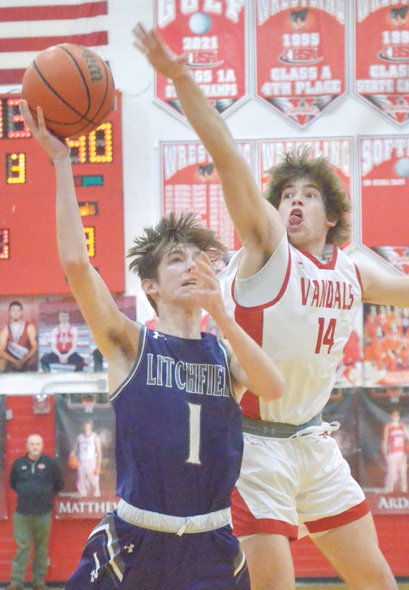 Vandalia's Matthew Hagy (#14) tries to block Litchfield's Clayton Bishop from behind in the third quarter of the Purple Panthers' 69-59 overtime win over the Vandals. With the win, Litchfield moves on to the semifinals of the Litchfield Regional, where they will face Alton Marquette at 6 p.m. Wednesday, Feb. 22.