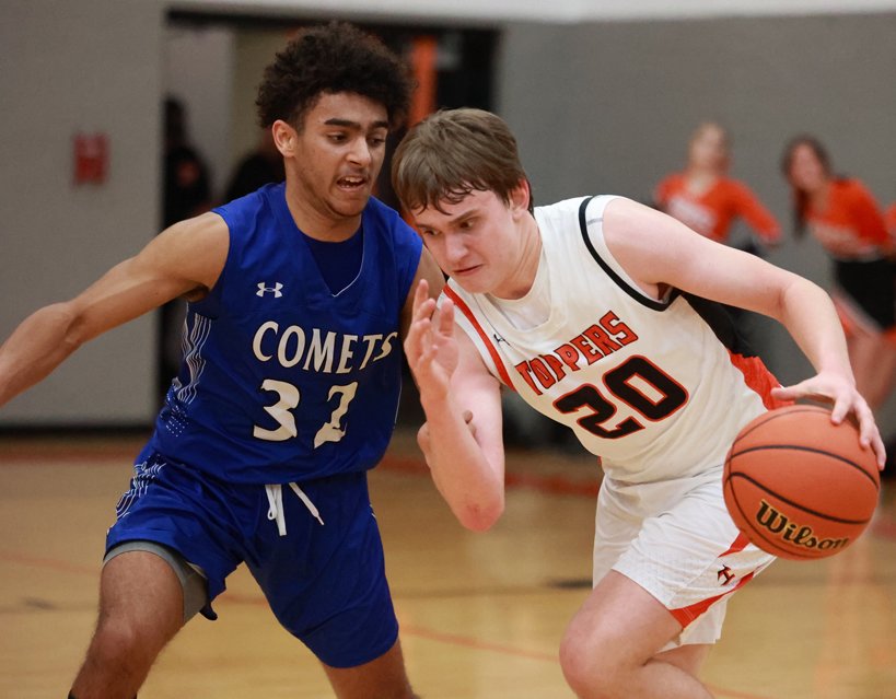 Hillsboro's Nathan Matoush tries to drive past Kaleb Gardner of Greenville during the Toppers' home game on Thursday, Feb. 16. Gardner had 17 points and two of Greenville's 12 threes as the Comets defeated Hillsboro 83-40.